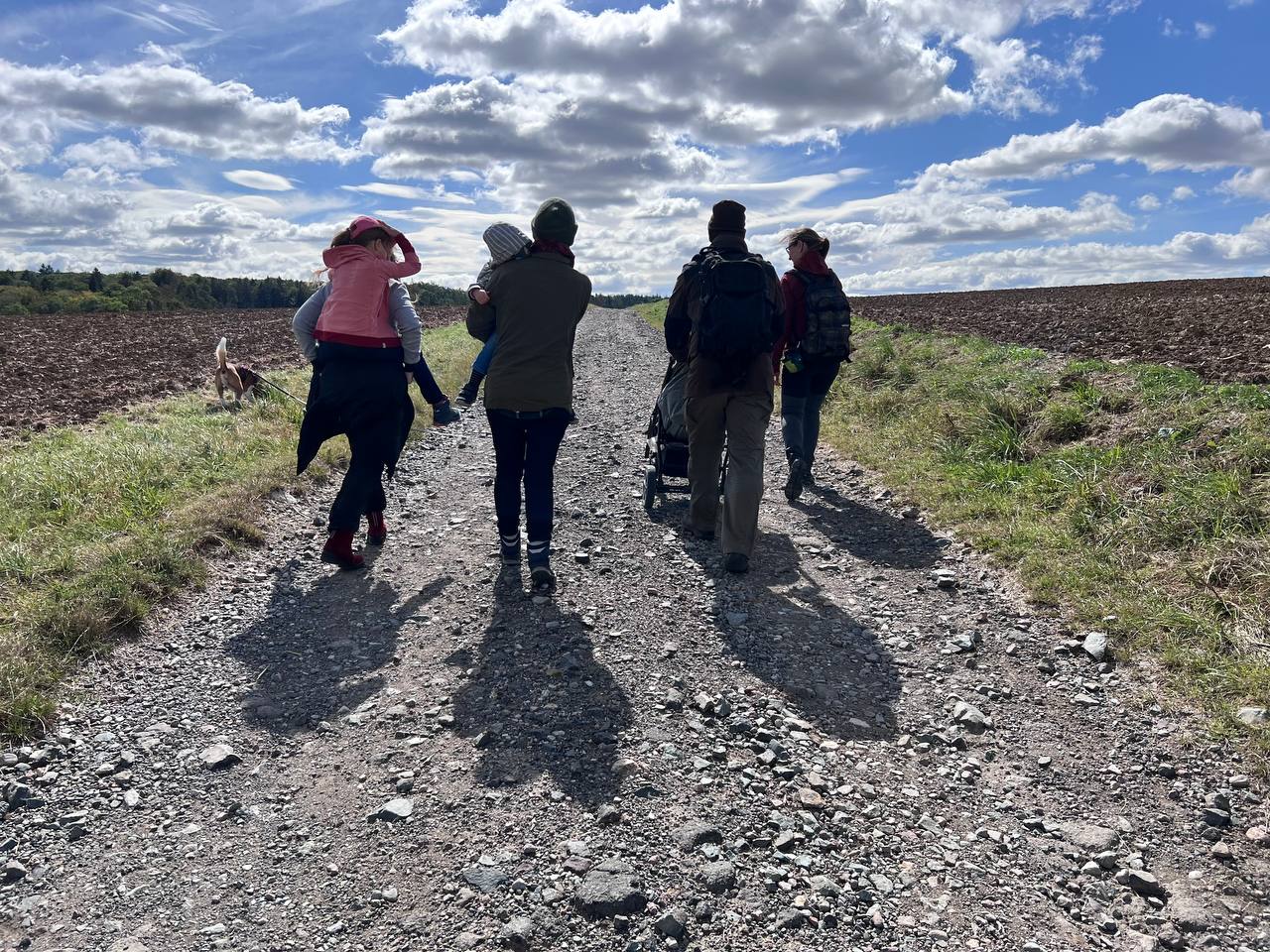 Personen bei schönem Wetter auf einer Wanderung im freien Feld