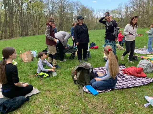 Wandergruppe bei der Rast auf einer Waldwiese